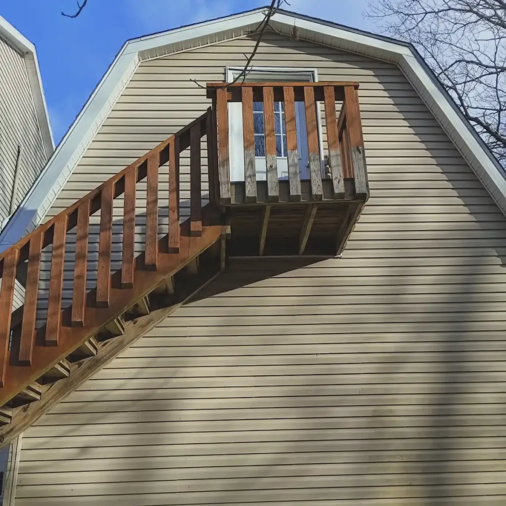 View of the entrance door up a flight of stairs.