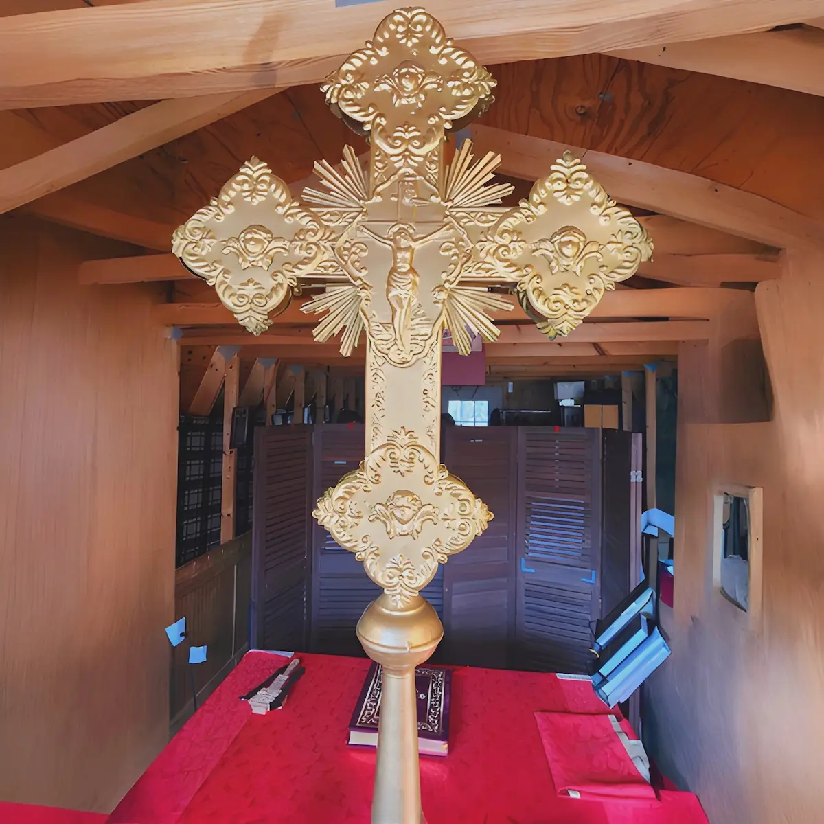 A single liturgical cross is shown behind the altar.