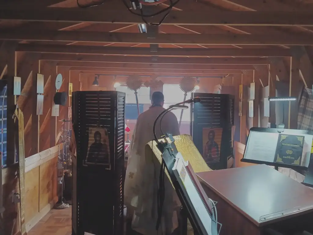 Father Gregory seen from the congregation's perspective during a service.