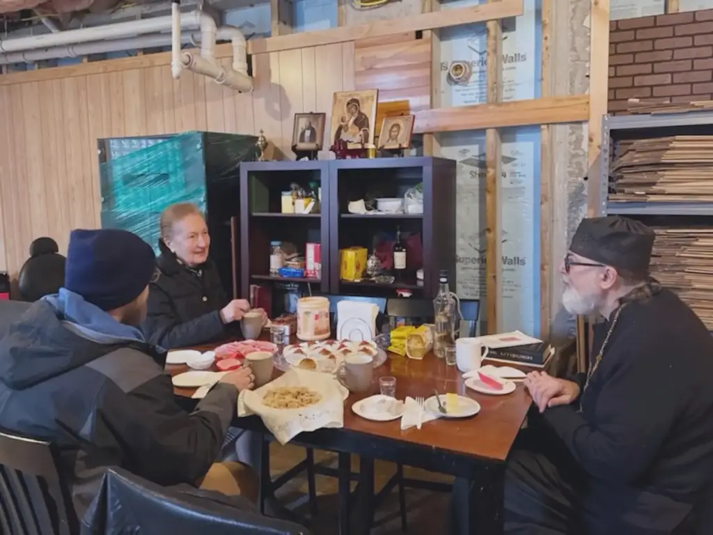 Parishioners and Father Gregory enjoy a meal during fellowship after service.
