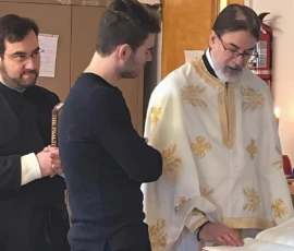 Parishioners and Father standing together and reading inside the church.