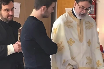 Parishioners and Father standing together and reading inside the church.