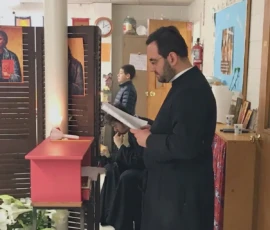 A parishioner reading at the chant stand during a service.