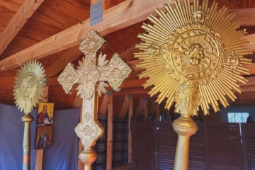 Liturgical cross and fans displayed behind the altar.