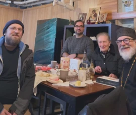 Parishioners and Father smiling for a photo after a fellowship gathering.