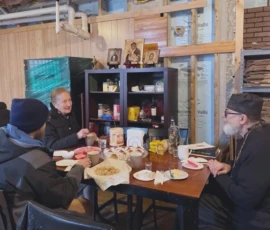 Parishioners and Father smiling and talking during fellowship.