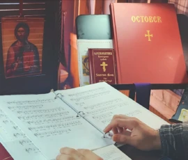 Hands holding a Byzantine chant book during a service.