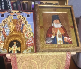 There are two icons resting on a stand. To the left is the icon of Pentecost. To the right is an icon of Saint Luke of Simferopol.