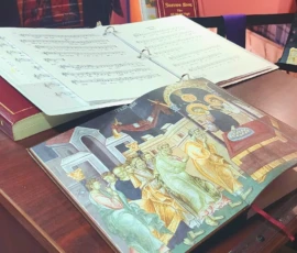 An open liturgical book turned to a page with an icon imprinted on it.