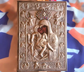 A silver Orthodox icon of the Theotokos holding the Christ Child, richly detailed with embossed figures and a crowned halo.
